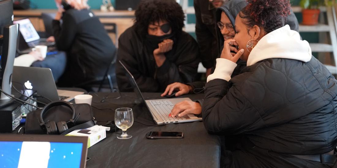 Workshop participants watching a game together on a laptop.